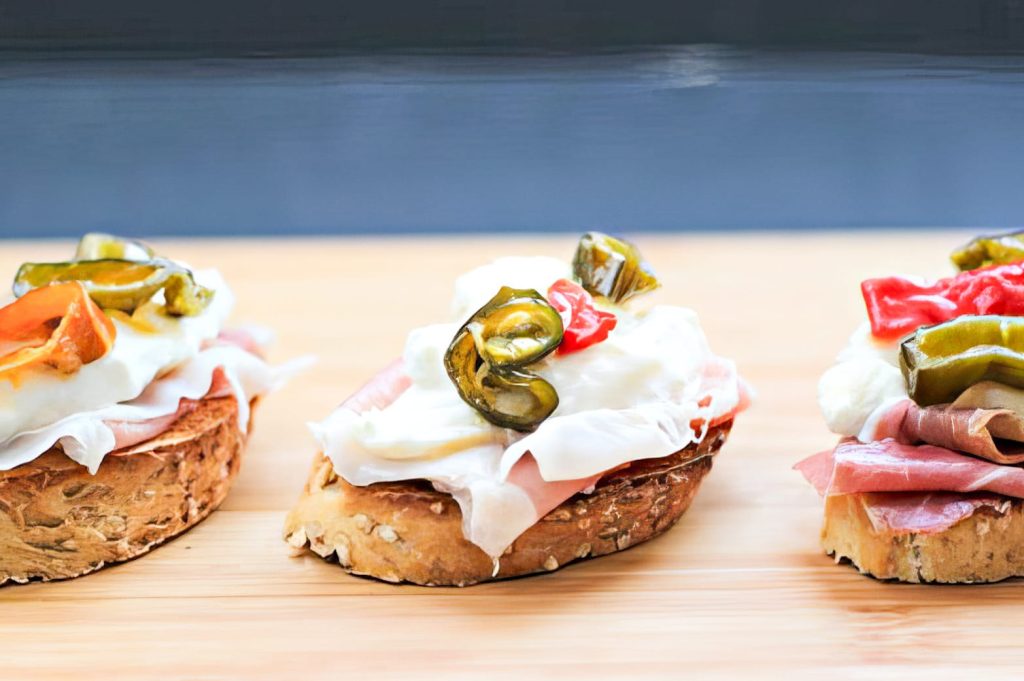 CROSTINI AL SESAMO CON SAN DANIELE, BURRATA E PEPERONI AGRODOLCI